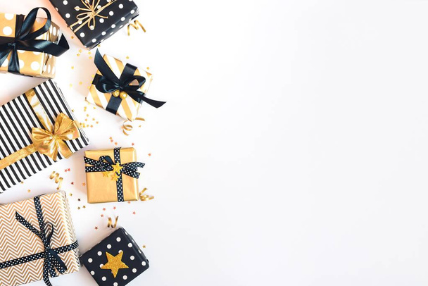 Ansicht von Geschenkboxen in verschiedenen schwarzen, weißen und goldenen Designs. flache Lage, Kopierraum. ein Konzept von Weihnachten, Neujahr, Geburtstagsfeier. - Foto, Bild