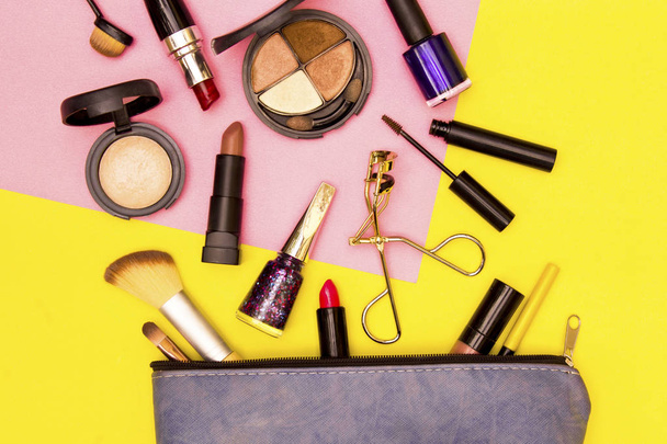 Make-up tas met cosmetica op gele en roze achtergrond. - Foto, afbeelding