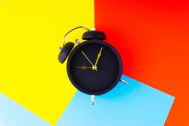 Horloge sur fond coloré avec mise au point sélective et fragment de culture. Concept d'espace de copie
 - Photo, image
