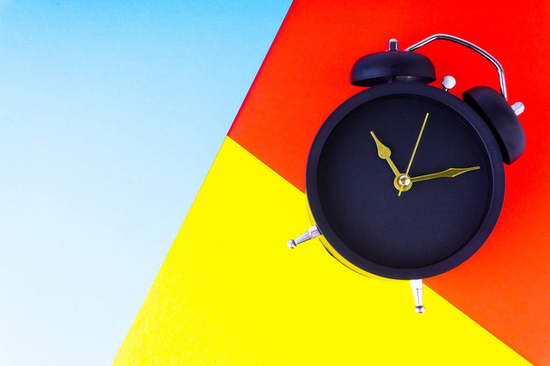Horloge sur fond coloré avec mise au point sélective et fragment de culture. Concept d'espace de copie
 - Photo, image