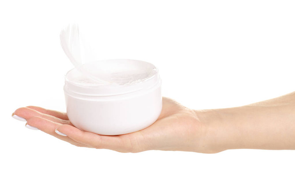 White jar of cream white feather in hand - Foto, immagini