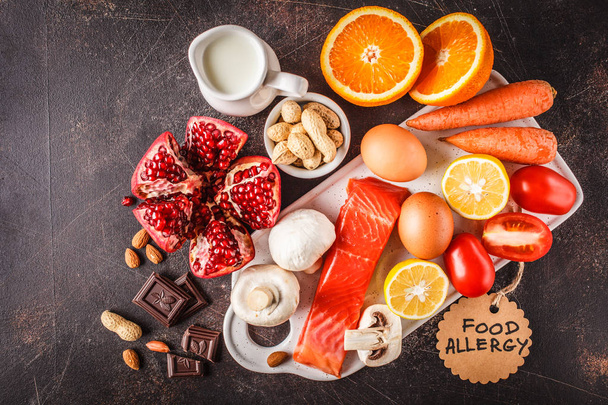 Allergy food concept. Allergies to fish, eggs, citrus fruits, chocolate, mushrooms and nuts. Health and medicine in food. Dark background, top view, copy space. - Photo, image