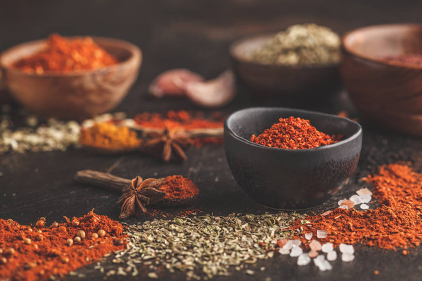 Different kind of spices in wooden bowls on dark background. Food background. - Foto, Imagem