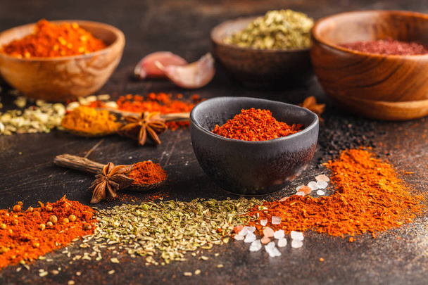 Different kind of spices in wooden bowls on dark background. Food background. - Foto, imagen