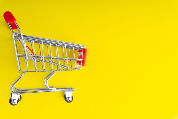 Shopping cart or trolley on colorful background with copy space and selective focus - Foto, Bild