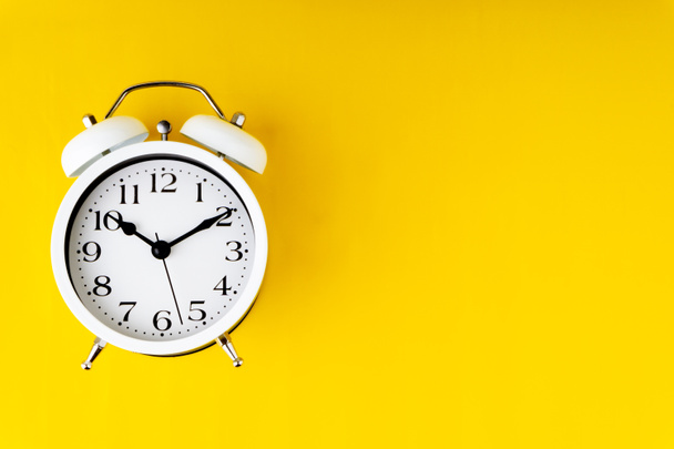 Clock on yellow background with selective focus and crop fragment. Copy space concept - Φωτογραφία, εικόνα
