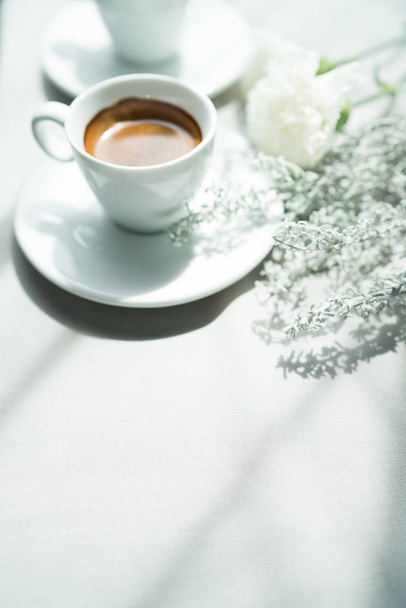 fehér csésze eszpresszó kávét és habcsók cookie-kat a fából készült asztal felülnézet, szárított virágot háttér, szép reggeli a kávézó - Fotó, kép