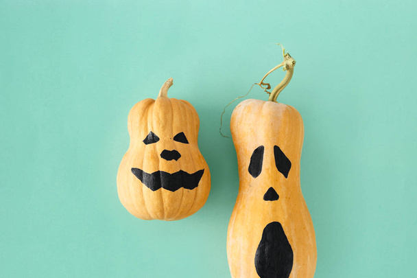  two funny scary face Halloween pumpkins on turquoise background - Фото, зображення
