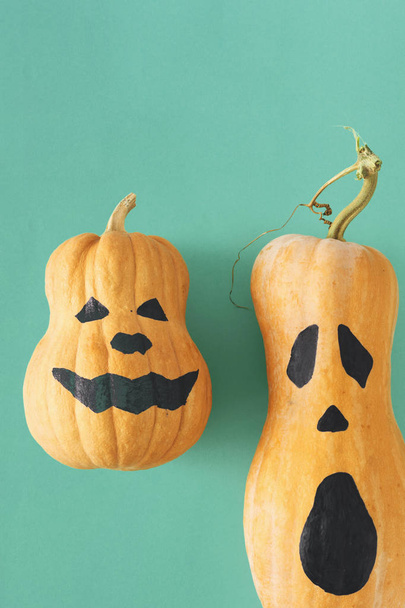  two funny scary face Halloween pumpkins on turquoise background - Photo, Image