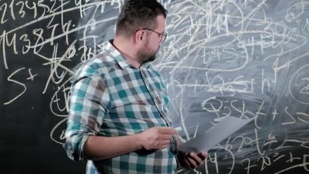 Een briljante volwassen wiskundige brengt een groot bord en voltooit een essay ingewikkelde wiskundige formule vergelijking - Video