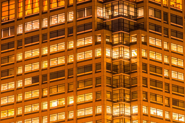 Schönes Gebäude im Außenbereich und Architektur des Gebäudes mit Fenster und Lichtmuster in der Nacht - Foto, Bild