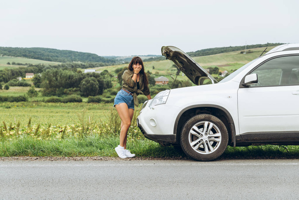 Žena v těsné košile nová rozbité auto s otevřenou kapotou. Road trip problémy - Fotografie, Obrázek