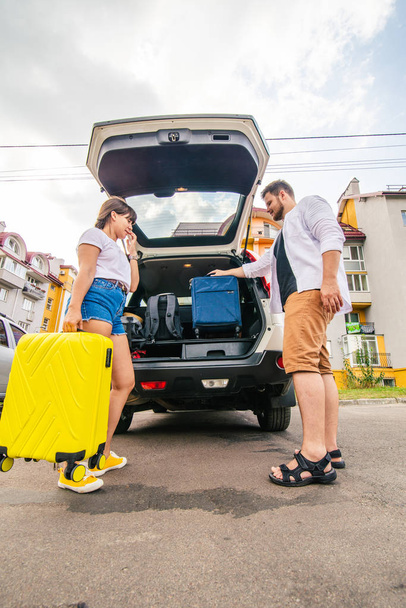couple packing bags in car trunk. road trip. car travel - Zdjęcie, obraz