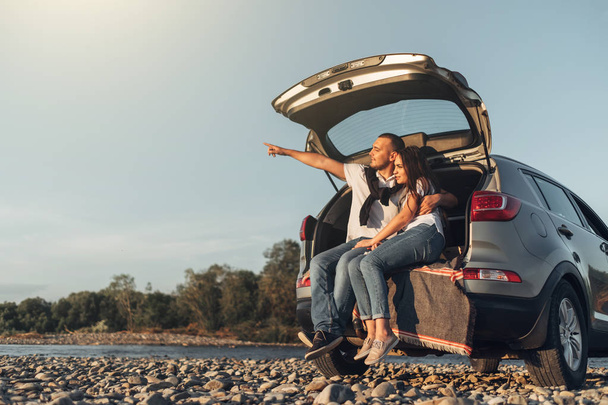 Happy Couple on Roadtrip into the Sunset in SUV Car - 写真・画像