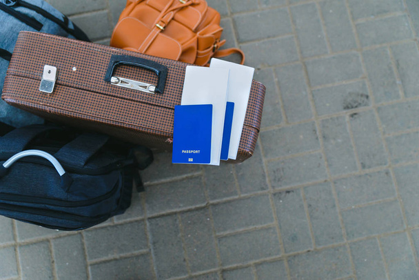 bolsas con pasaporte y billetes en ella cerca de la estación de tren. concepto de viaje
 - Foto, Imagen