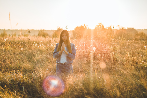girl closed her eyes, praying outdoors, Hands folded in prayer concept for faith, spirituality and religion. hope, dreams concept. - Photo, Image