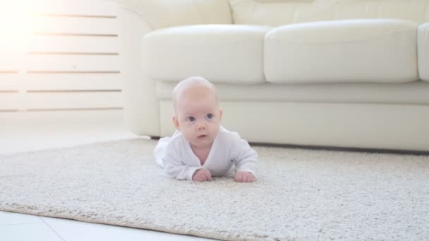 Leuke grappige baby liggend op een beige tapijt - Video