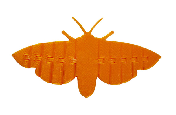 Helder lichtoranje object in de vorm van vlinderspeelgoed gedrukt op 3d printer - Foto, afbeelding