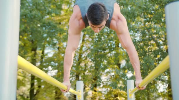 Exercice d'athlète masculin sur barres parallèles gymnastique
 - Séquence, vidéo
