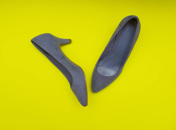 Жіноче блакитне взуття на жовтому тлі
 - Фото, зображення