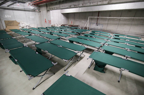 Camp skládací postýlky jsou právě nastaveny v podzemních garážích na stadionu a čekat na uprchlíky, během nácviku katastrofální zemětřesení v městě, ve kterém existuje mnoho obětí - Fotografie, Obrázek