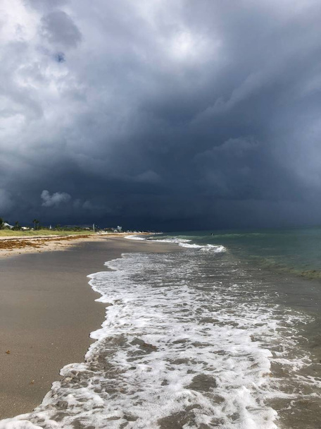 Tempestade rolando para a praia com nuvens escuras e destruição
 - Foto, Imagem