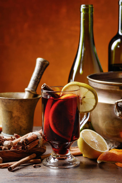Vin chaud aux épices et agrumes sur la table avec des ustensiles
 . - Photo, image