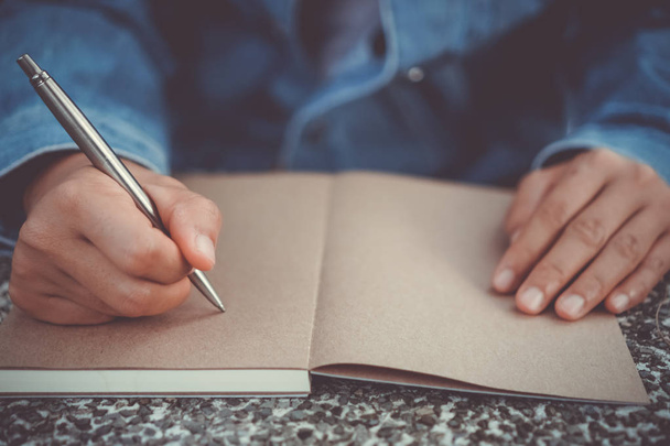 Copiar el espacio de la mano de la mujer escribiendo en cuaderno blanco con fondo bokeh colorido. - Foto, Imagen