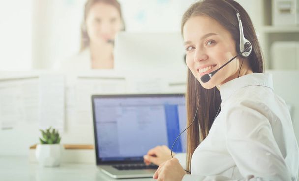 Smiling businesswoman or helpline operator with headset and computer at office - Foto, Imagen