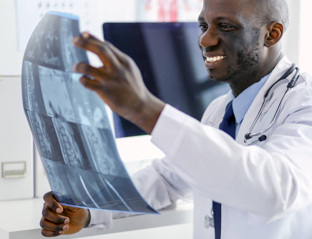 Portrait young african medical doctor holding patients x-ray - Foto, Bild