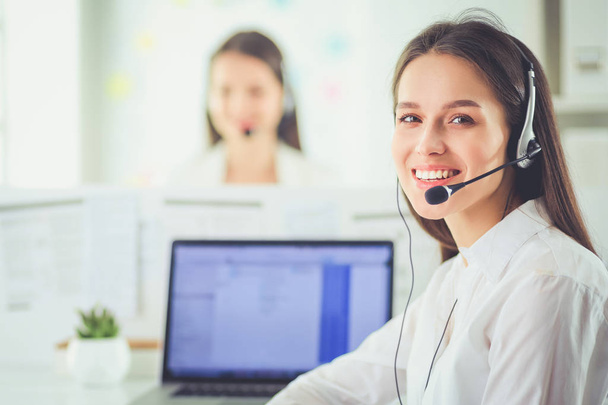 Smiling businesswoman or helpline operator with headset and computer at office - Фото, зображення