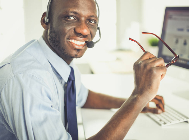 African american businessman on headset working on his laptop - Zdjęcie, obraz