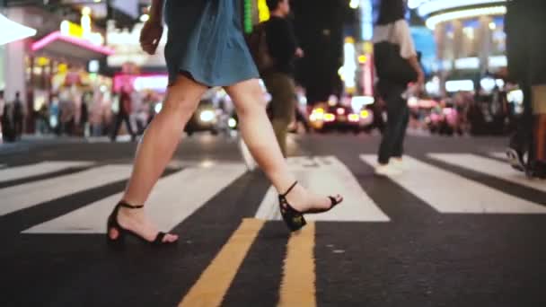 Slow-motion shot van de levensstijl van mooie jonge vrouwelijke benen lopen over drukke straat 's nachts in Times Square, New York. - Video