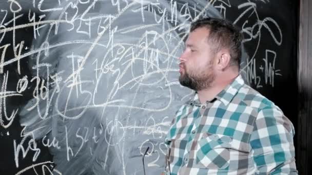 A brilliant mature mathematician brings a big board and completes an essay Complicated mathematical formula equation - Footage, Video