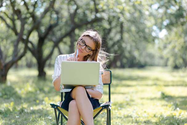 Woman with a laptop in the Park sitting on a folding chair - Фото, зображення
