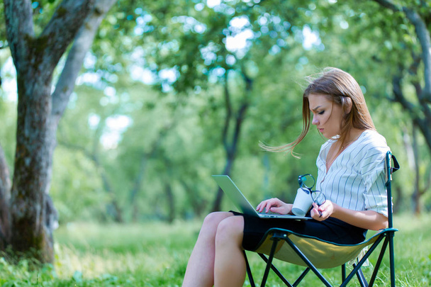 Business woman using laptop on lunch break in city park  - Photo, Image