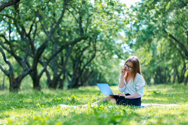 Femme d'affaires utilisant un ordinateur portable pendant la pause déjeuner dans le parc de la ville
  - Photo, image