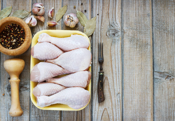 Bowl with raw chicken legs on wooden background, top view - Fotoğraf, Görsel