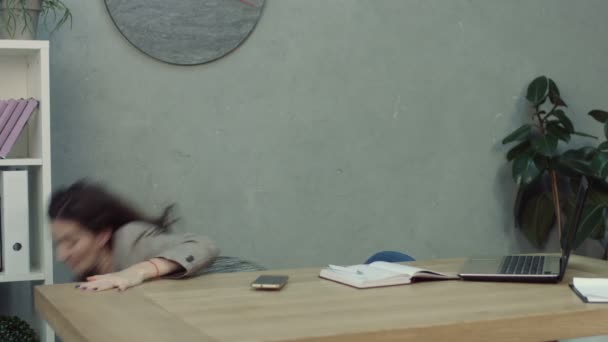 Overworked tired businesswoman awakened by phone call while taking a nap at her workplace with her feet on office desk. Exhausted female entrepreneur waking up by phone ring in office. - Materiał filmowy, wideo
