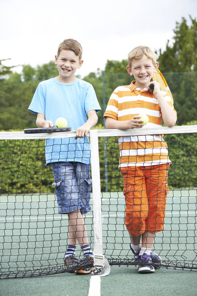 Portrait Of Two Boys Playing Tennis Together - Foto, afbeelding