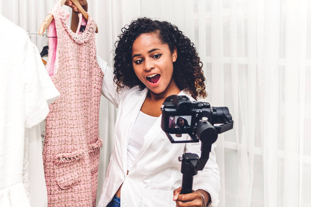 ショッピング store.fashion ショッピング、ソーシャル メディア コンセプトで服を選ぶ彼女自身を記録カメラの前でアフリカ系アメリカ人の女性ブロガーに立って - 写真・画像