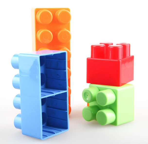 Пластиковые красочные игрушечные блоки на белом фоне
 - Фото, изображение