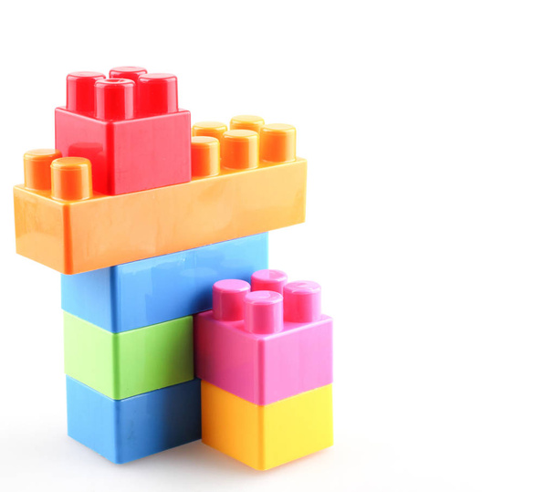 Пластиковые красочные игрушечные блоки на белом фоне
 - Фото, изображение