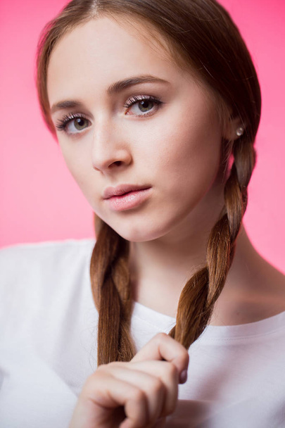 Closeup portrait of young teen girl with pigtails on pink background - Foto, immagini