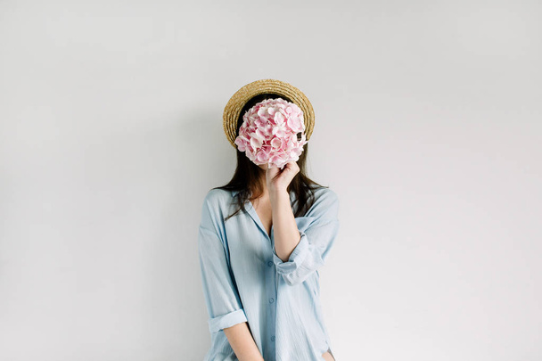 Nuori nainen pitää vaaleanpunainen hortensia kukka kukkakimppu valkoisella taustalla. Tasainen lay, top view kukka kauneus muoti käsite
. - Valokuva, kuva