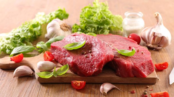 Raw beef fillet with vegetables on wooden board - Foto, Imagen