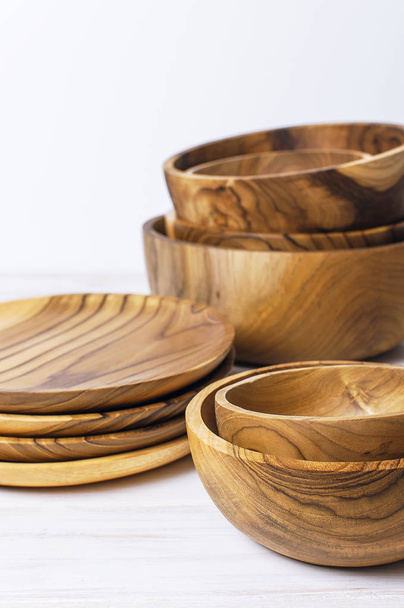 Utensilios de madera para la cocina, cuencos, platos sobre un fondo claro. El concepto de platos naturales, un estilo de vida saludable
. - Foto, Imagen