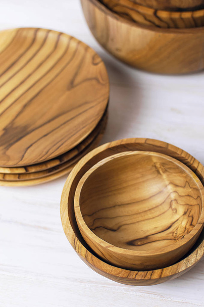 Wooden utensils for the kitchen, bowls, plates on a light background. The concept of natural dishes, a healthy lifestyle. - Foto, Imagem