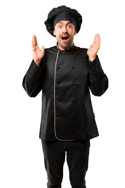 Chef man In black uniform with surprise and shocked facial expression. Mouth open because not expect what has happened on isolated white background - Photo, Image
