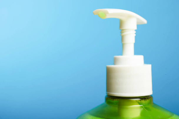 Green liquid soap on blue background. Concept hygiene. - Photo, Image